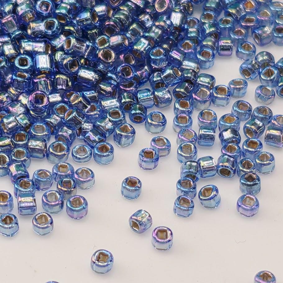 a large pile of small, blue beads scattered across a white background.