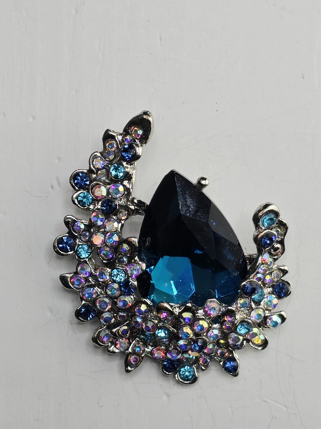 a large, blue gemstone set in an ornate, silver-colored frame.