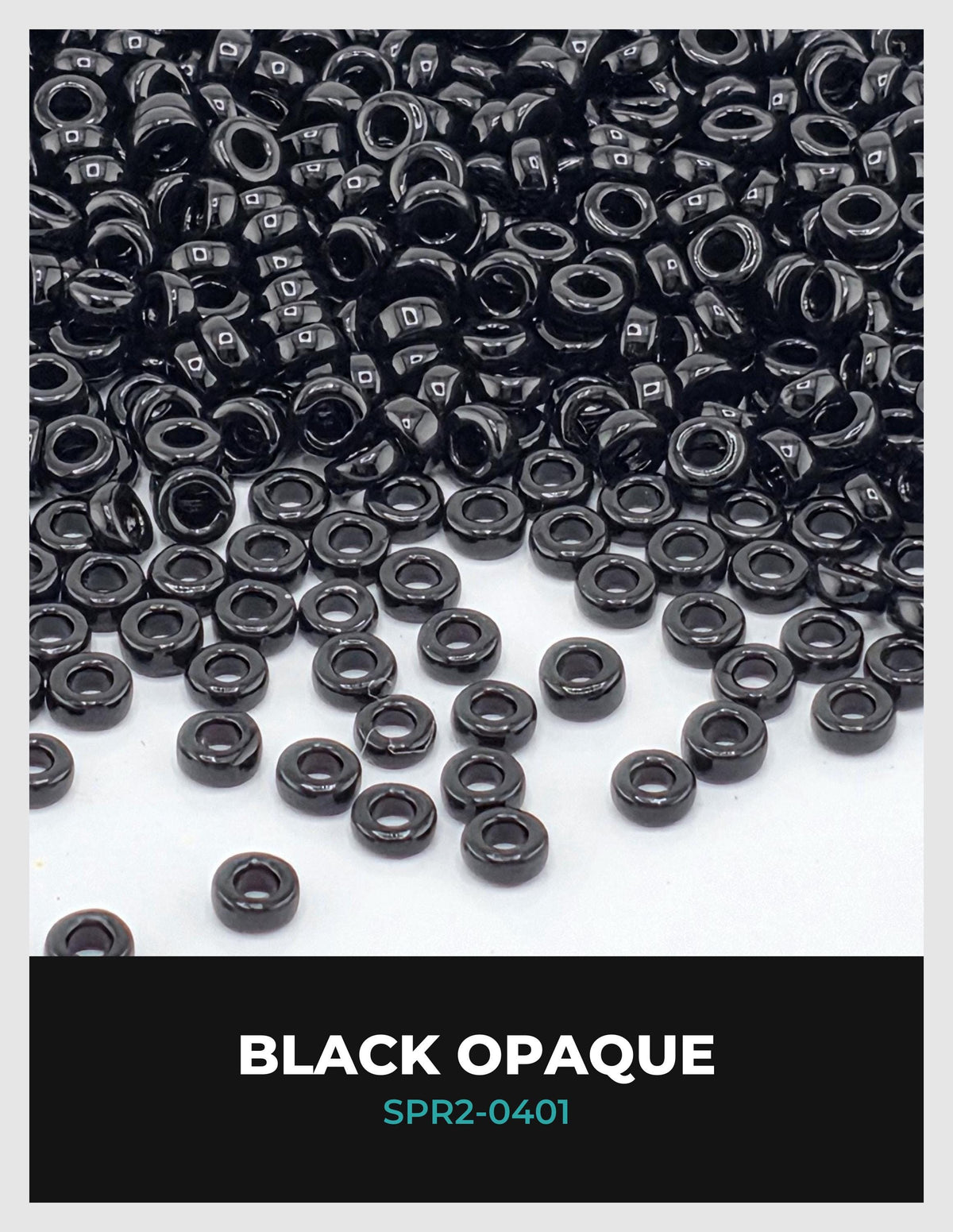 a large pile of black beads or buttons scattered across a white background.