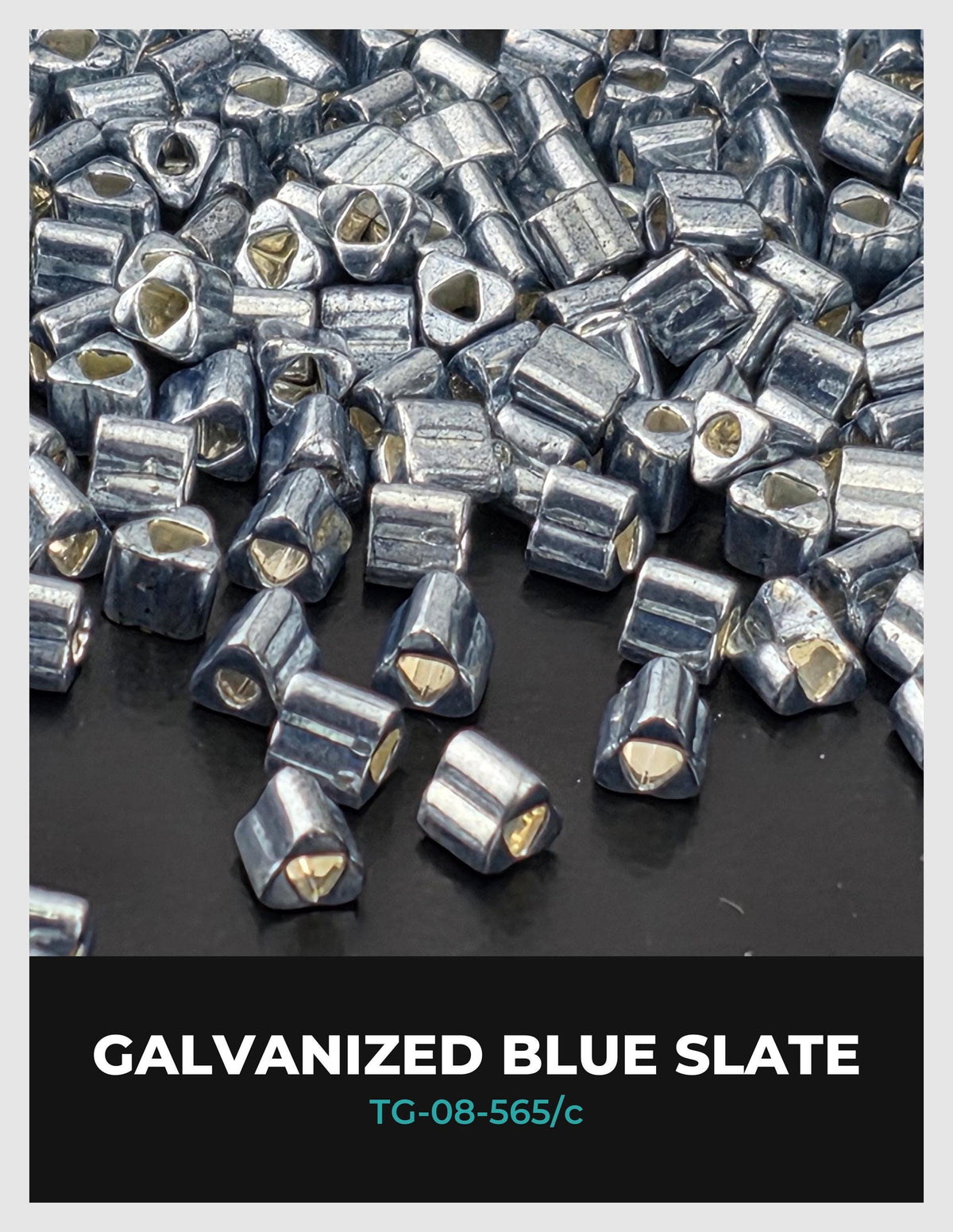 a collection of small, metallic blue slate pieces scattered on a dark surface.