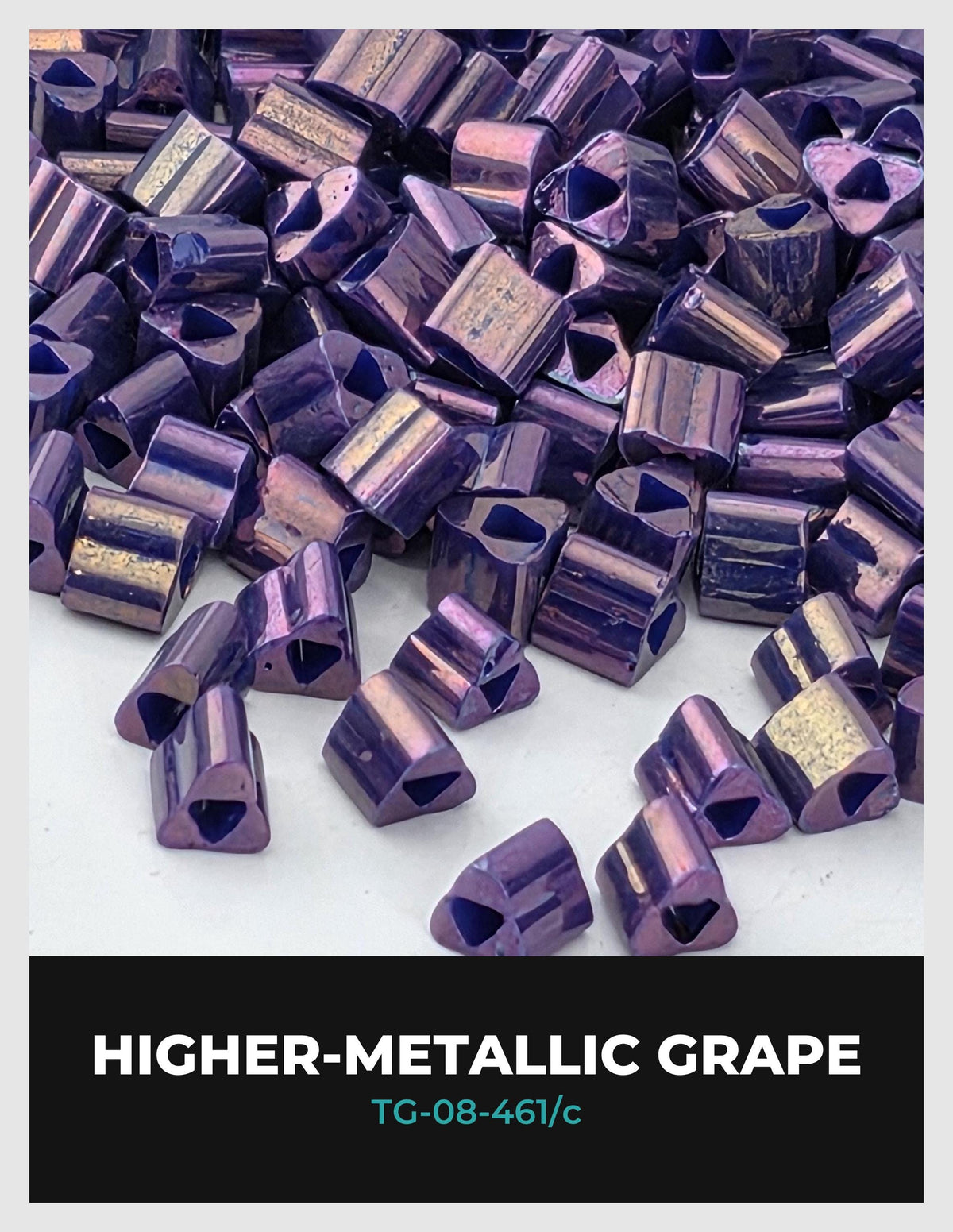 a collection of purple and gold metallic beads or beads in various shapes and sizes, scattered on a white surface.