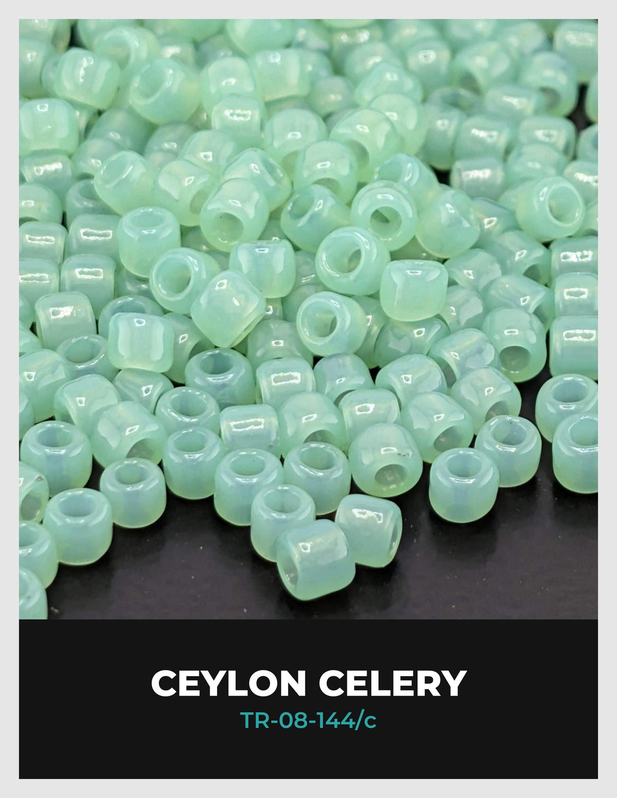a collection of small, clear beads in various shades of green, scattered on a dark background.