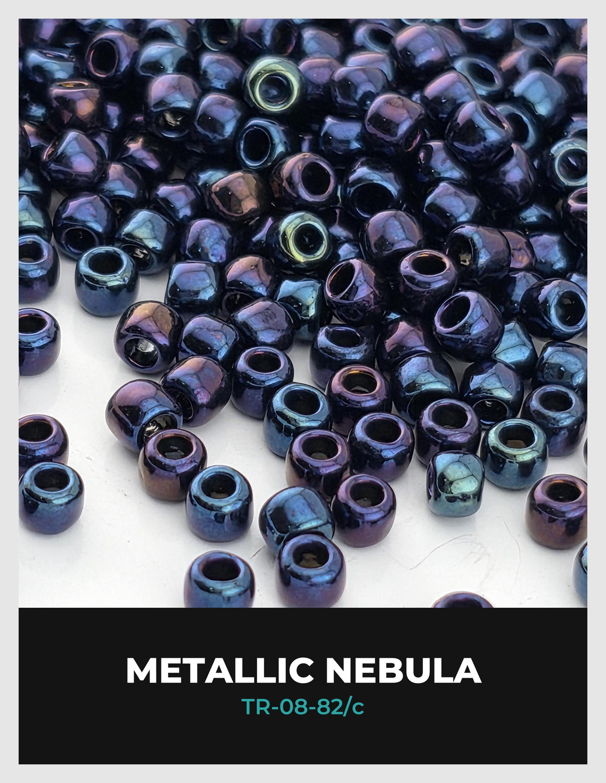 a collection of metallic blue and purple beads, resembling the appearance of a nebula, scattered across a white background.