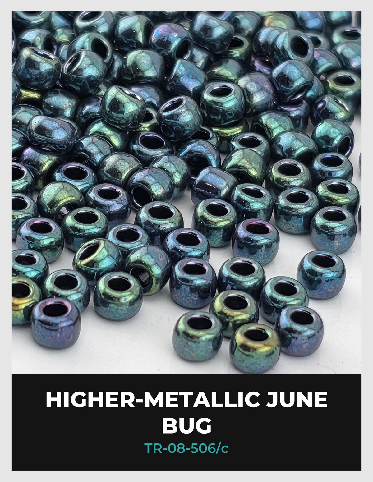 The image is a close-up of numerous metallic beads in various shades of green and blue, scattered across a surface.