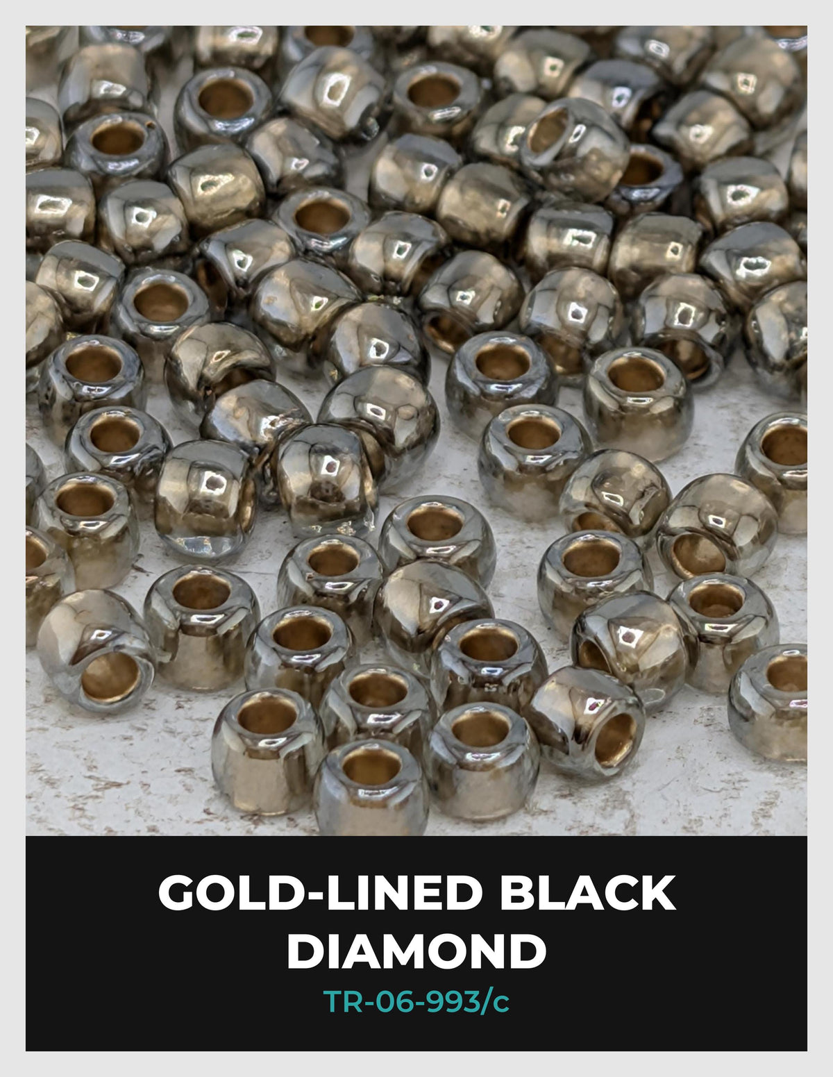 a collection of small, shiny, black beads arranged in a pattern, with some of the beads appearing to be gold-colored.