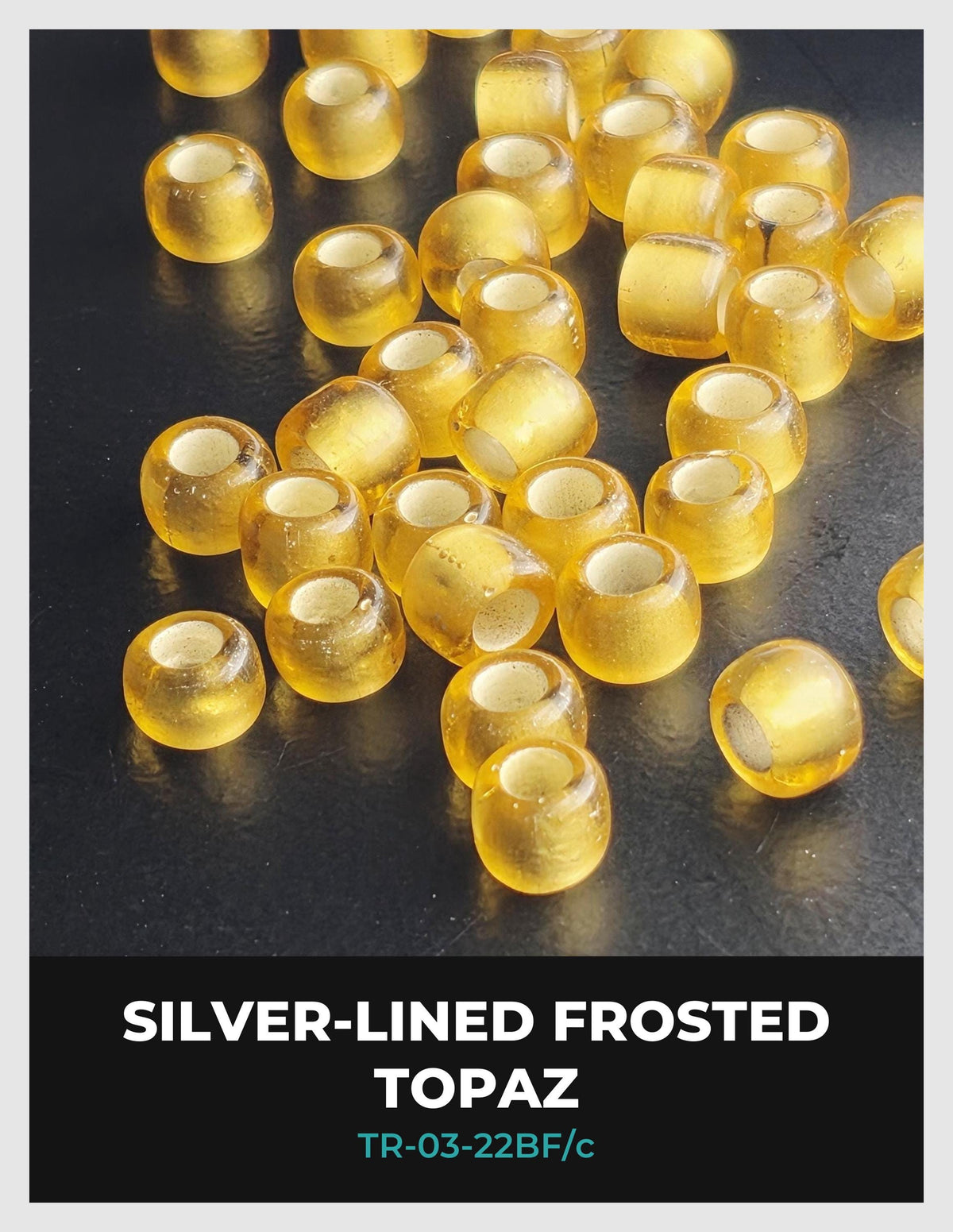 a collection of small, round, yellow-colored objects arranged on a dark surface, with some of them appearing to be frosted or coated with a silver-like material.