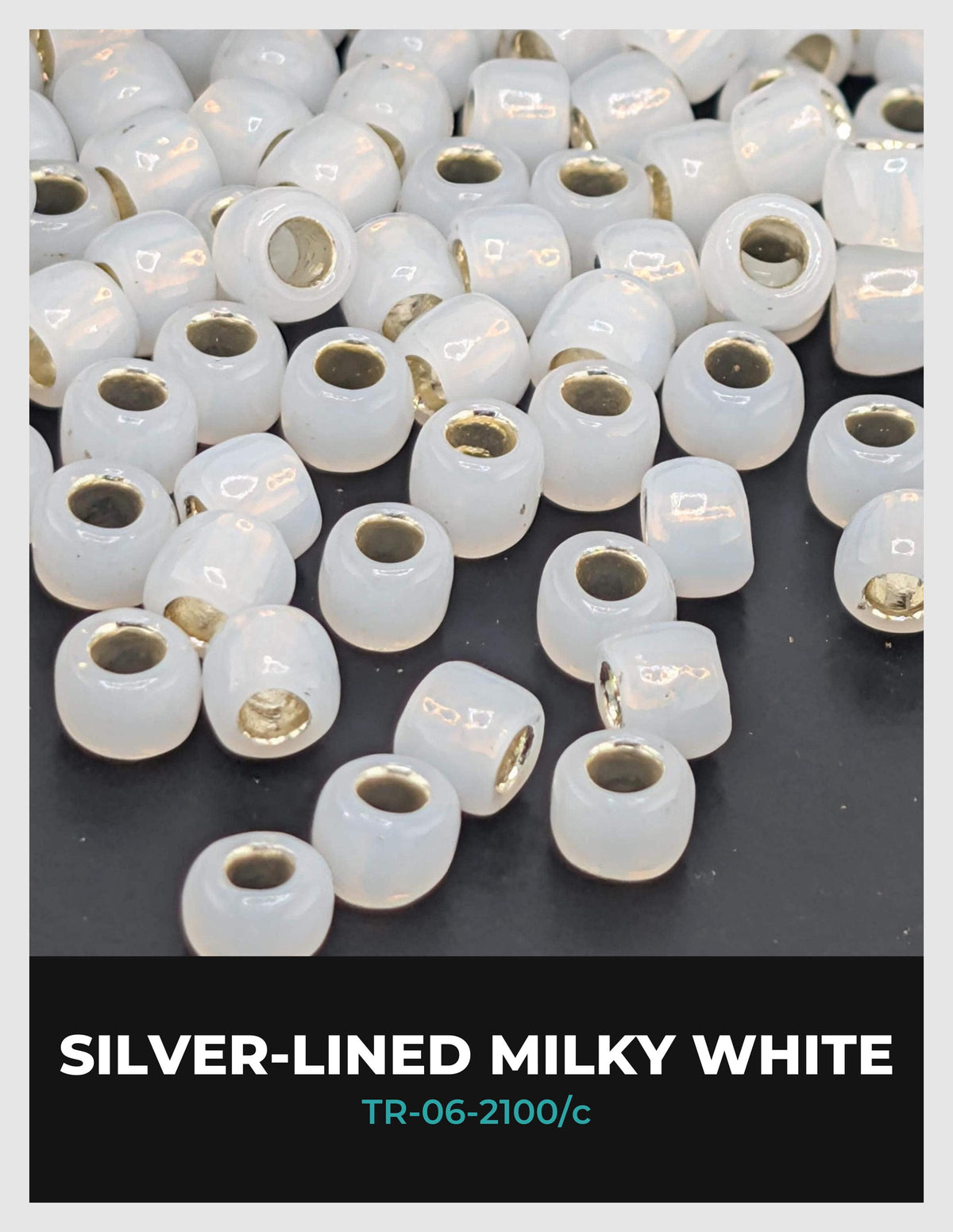 a collection of white, round beads with gold accents, arranged in a scattered pattern on a dark background.