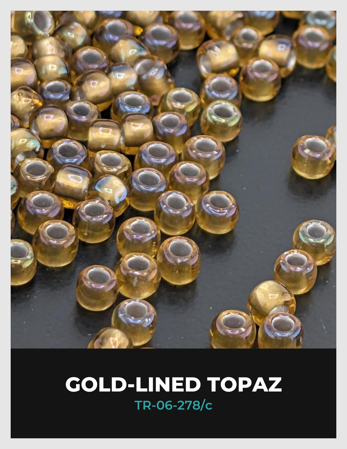 a collection of gold-colored glass beads or topaz beads scattered on a dark surface.