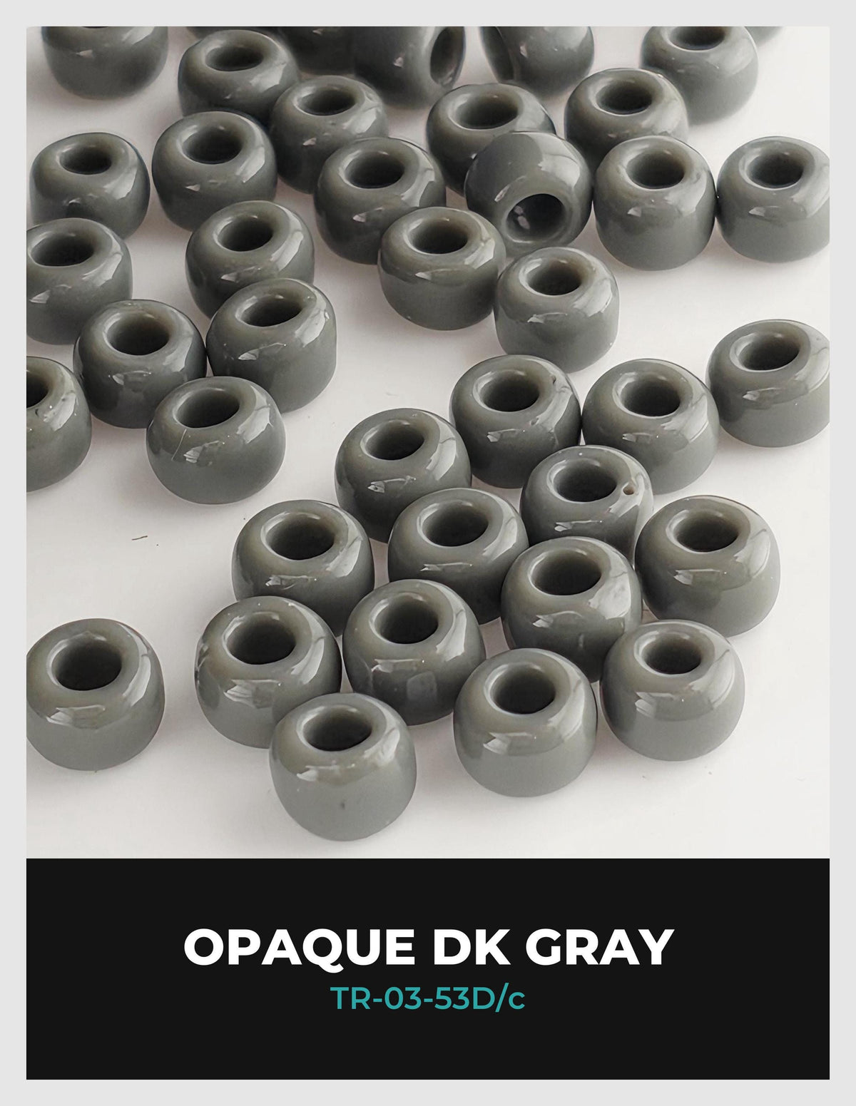 a collection of grey, circular objects arranged in a pattern, likely beads or buttons, with a black background.