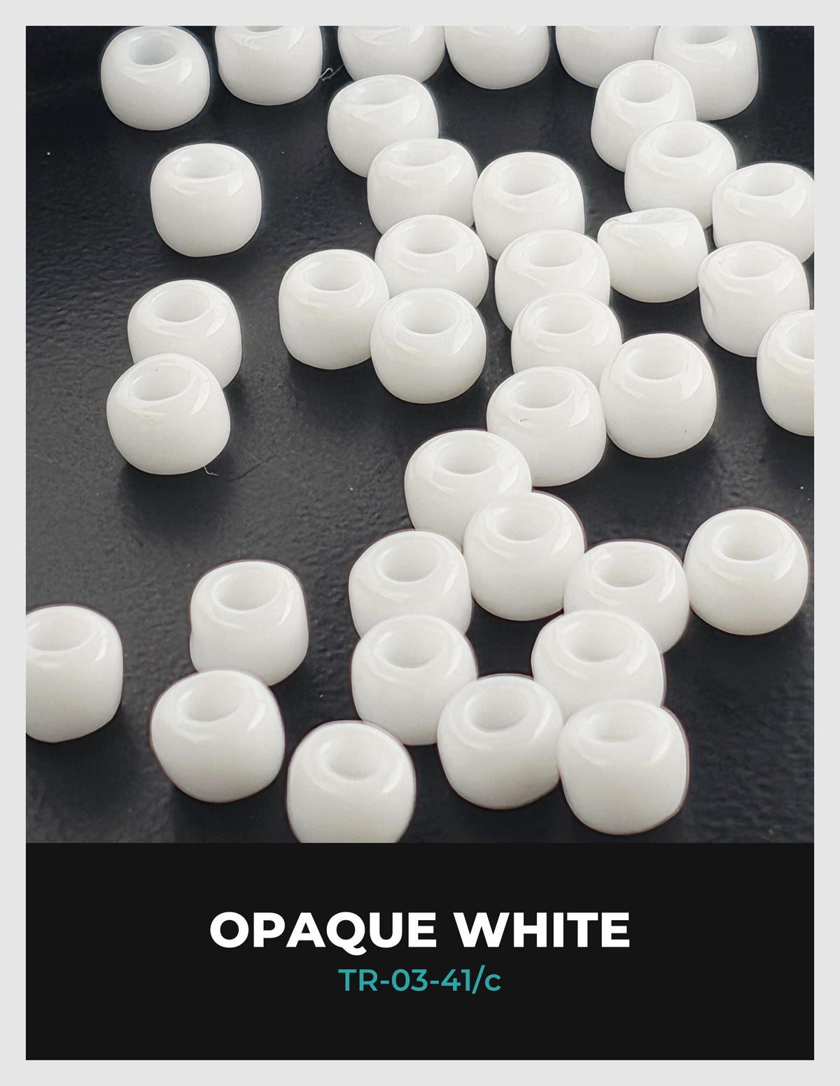 a collection of white, round beads scattered on a dark surface.