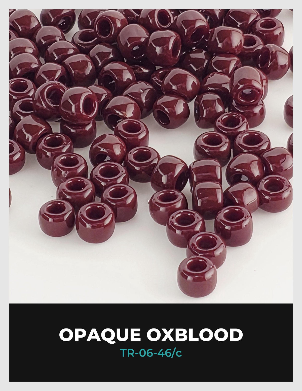a collection of maroon-colored beads or beads, possibly made of glass or plastic, scattered across a white background.