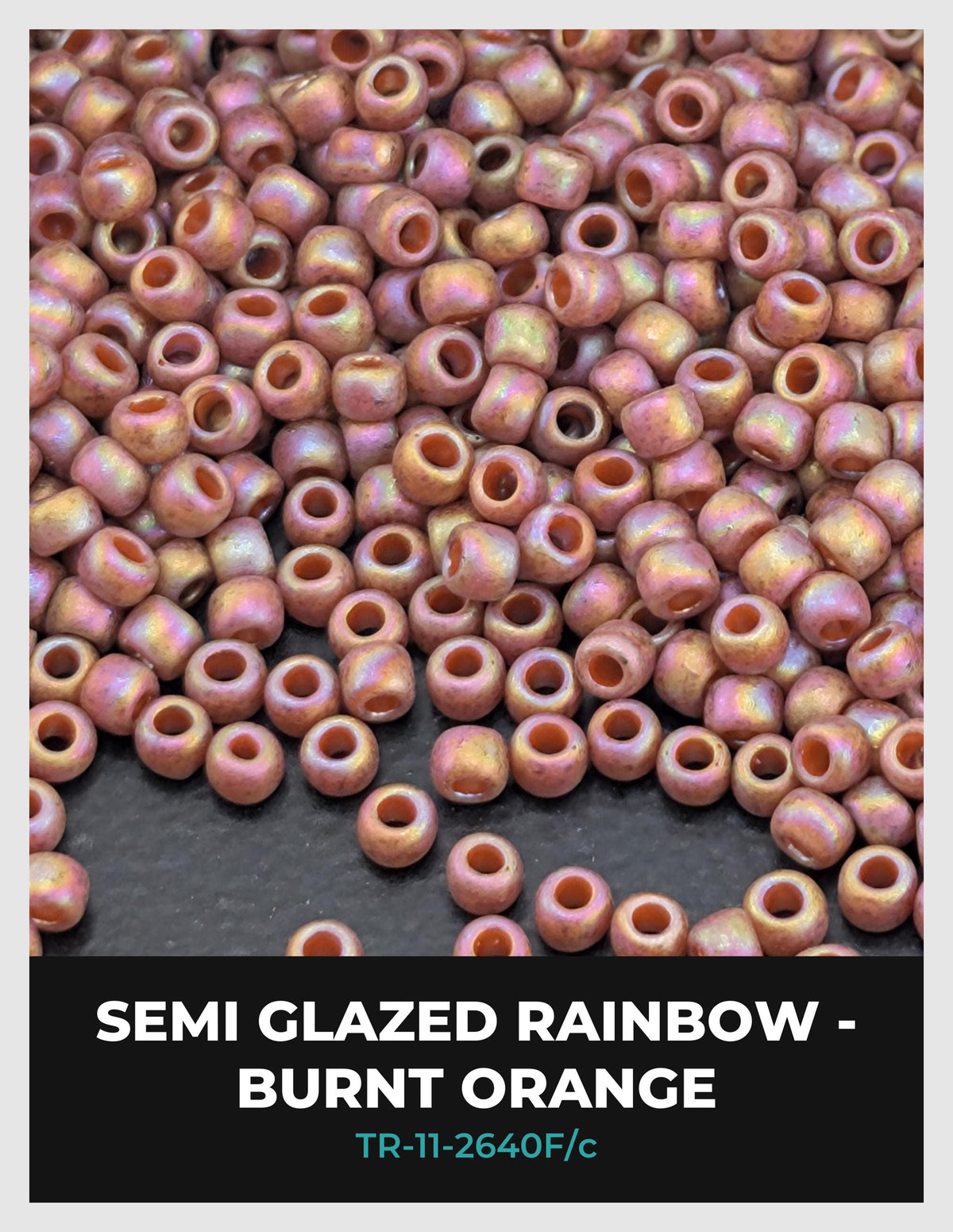 a large pile of semi-glazed rainbow-colored beads, including burnt orange and burnt red, scattered on a dark surface.