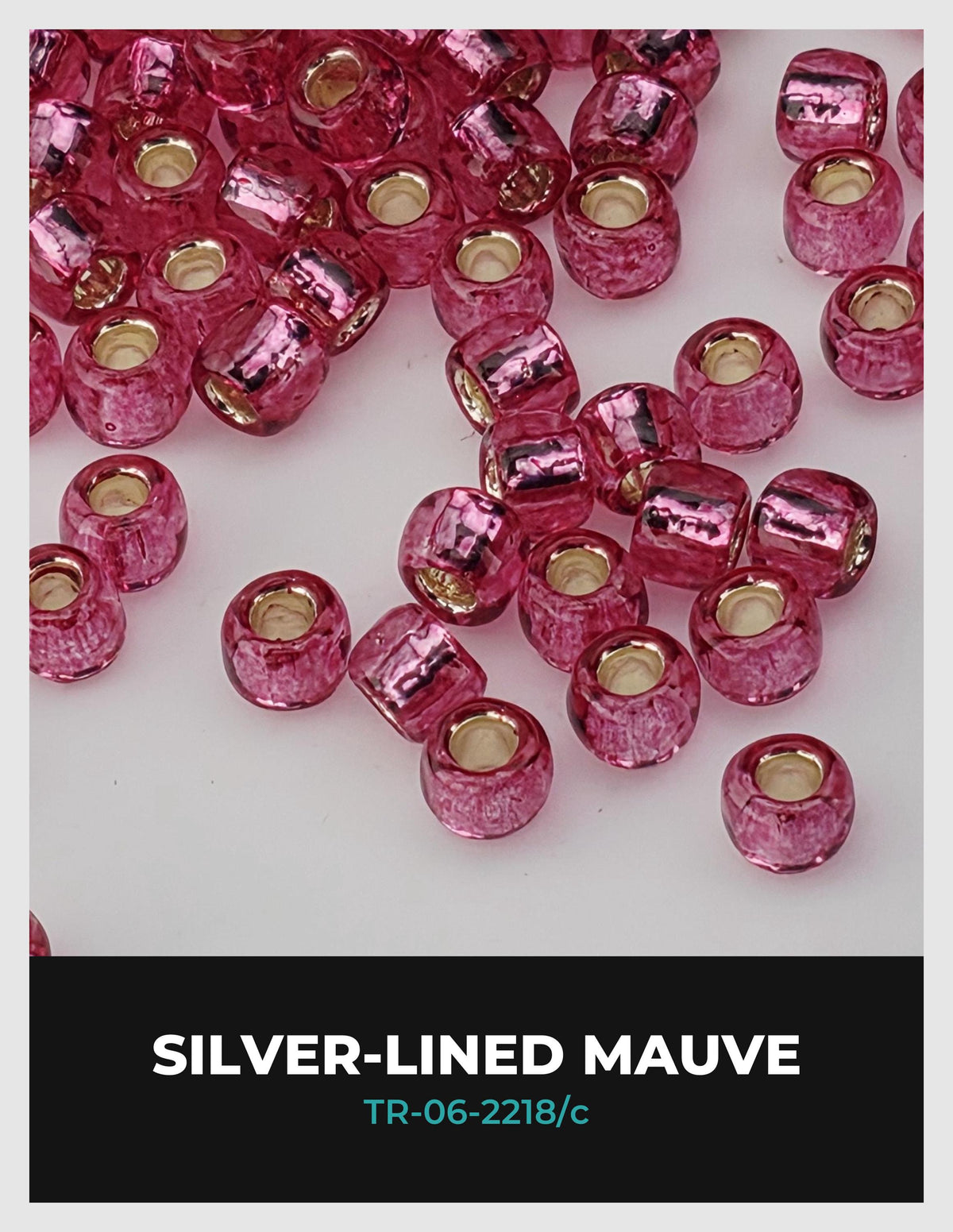 a collection of pink glass beads scattered on a white background.