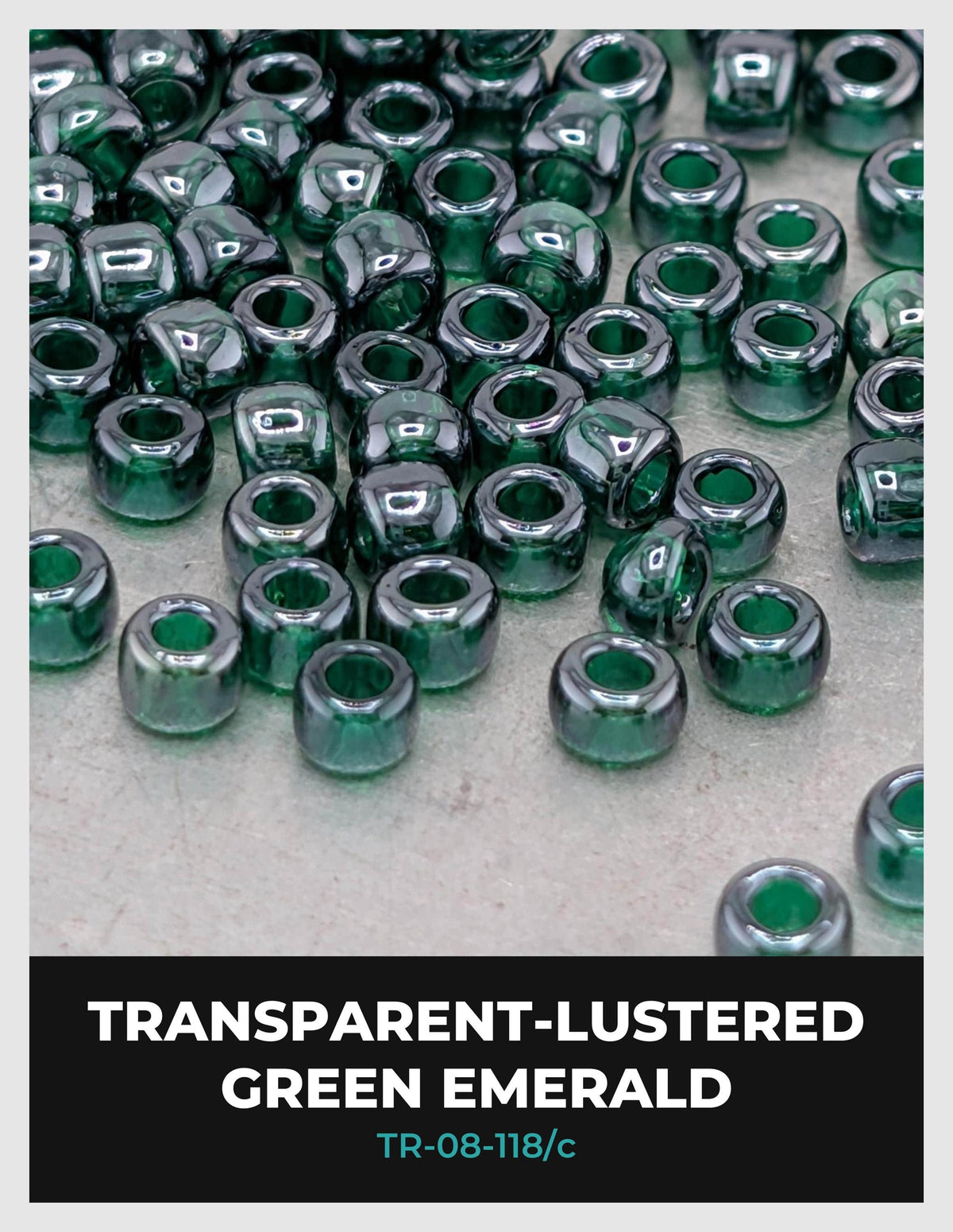 a collection of green emerald beads scattered on a surface, with the text "TRANSPARENT-LUSTERED GREEN EMBRELLA" and "TR-08-118/c" visible.