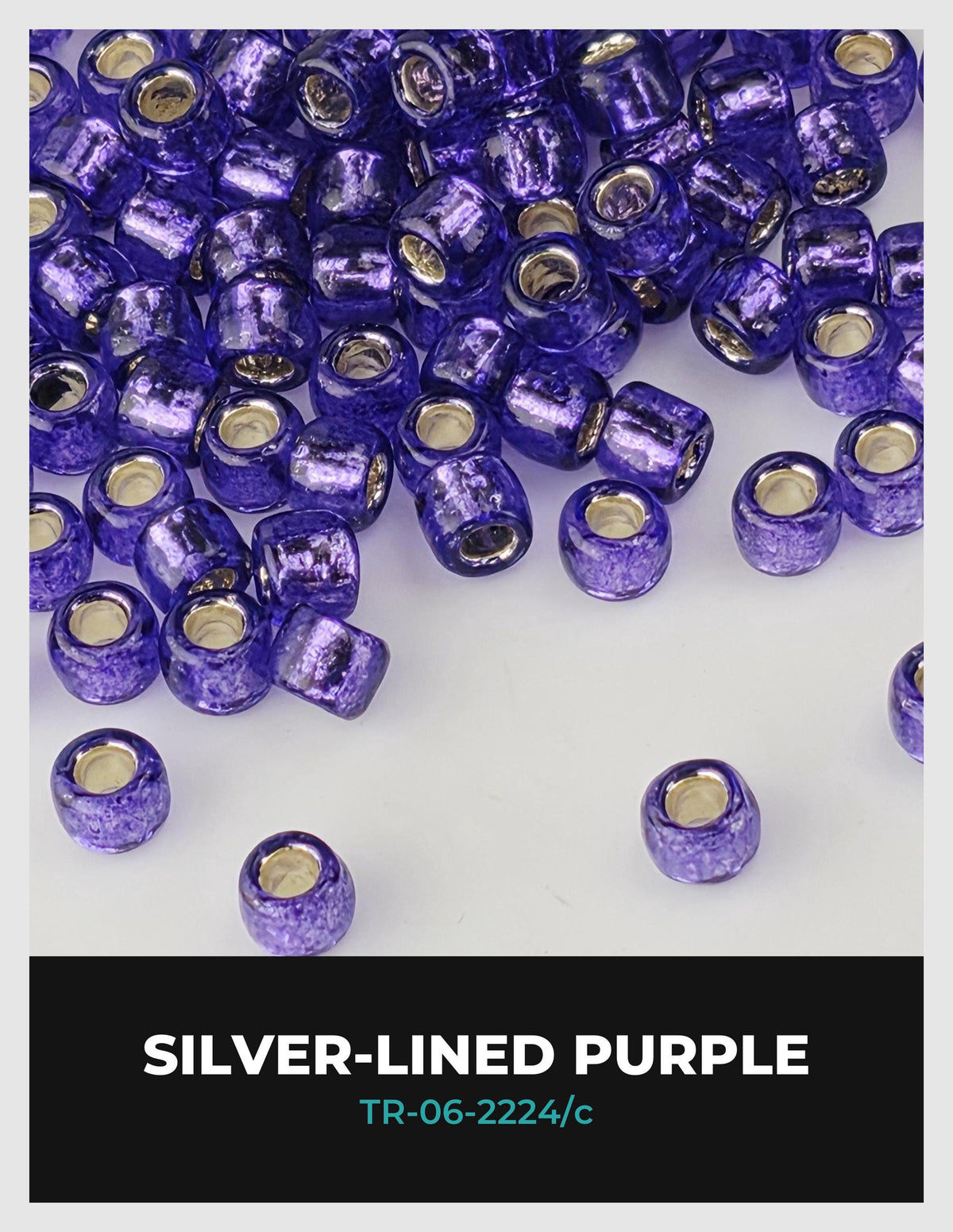 a collection of purple glass beads scattered on a white background.