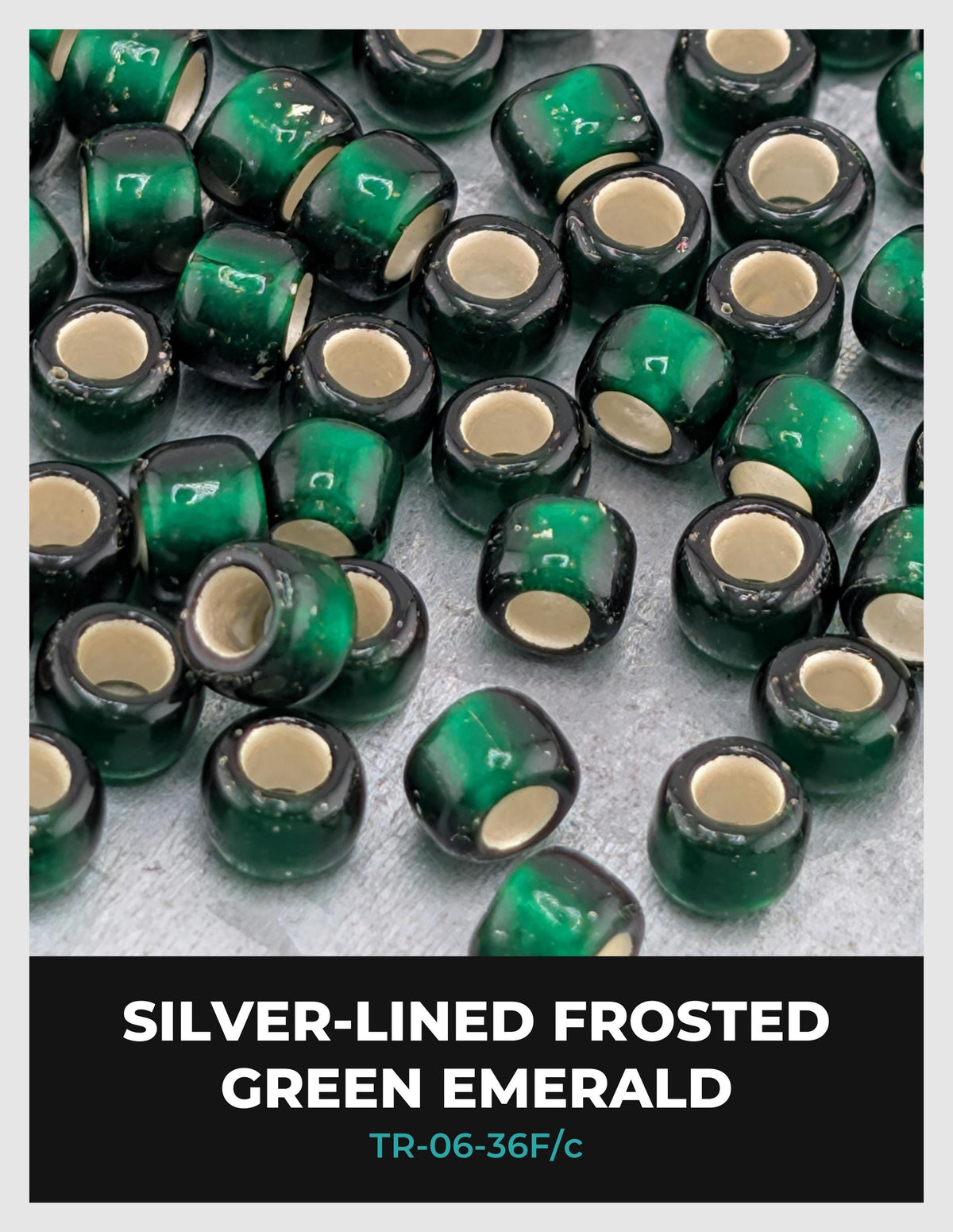 a collection of green emerald-colored beads with silver-lined frosted edges, arranged on a surface.