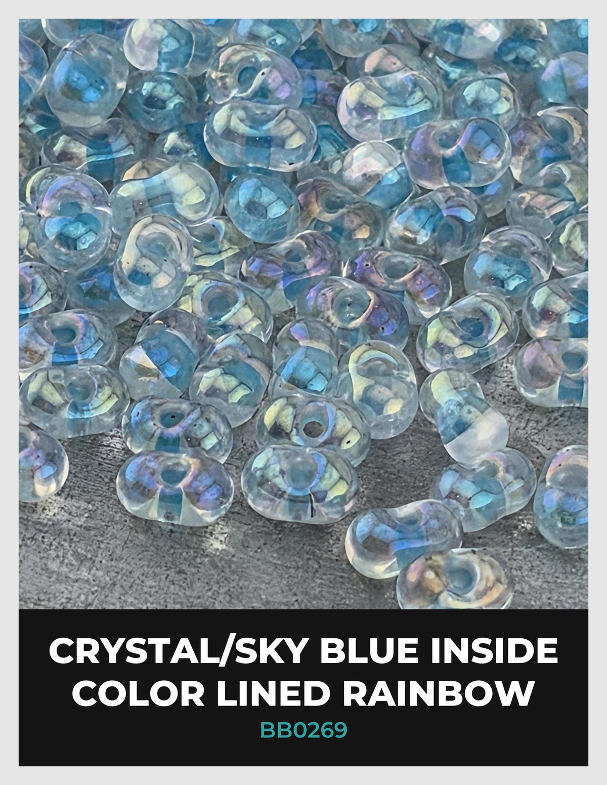 The image is a close-up of numerous clear beads with a blue color inside, arranged in a color-lined rainbow pattern.