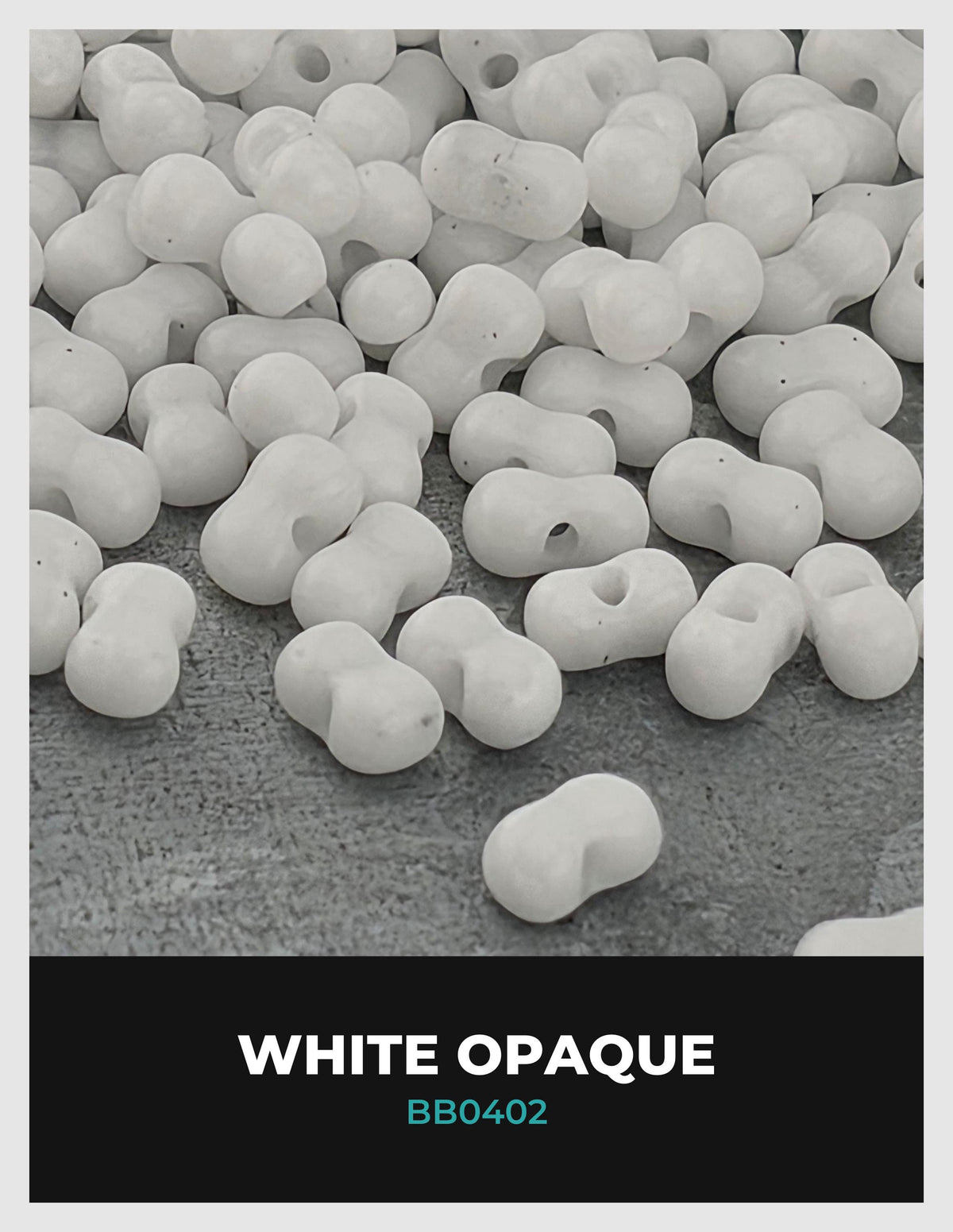The image is a close-up of numerous white, spherical objects, possibly beads or beads, scattered on a textured surface.