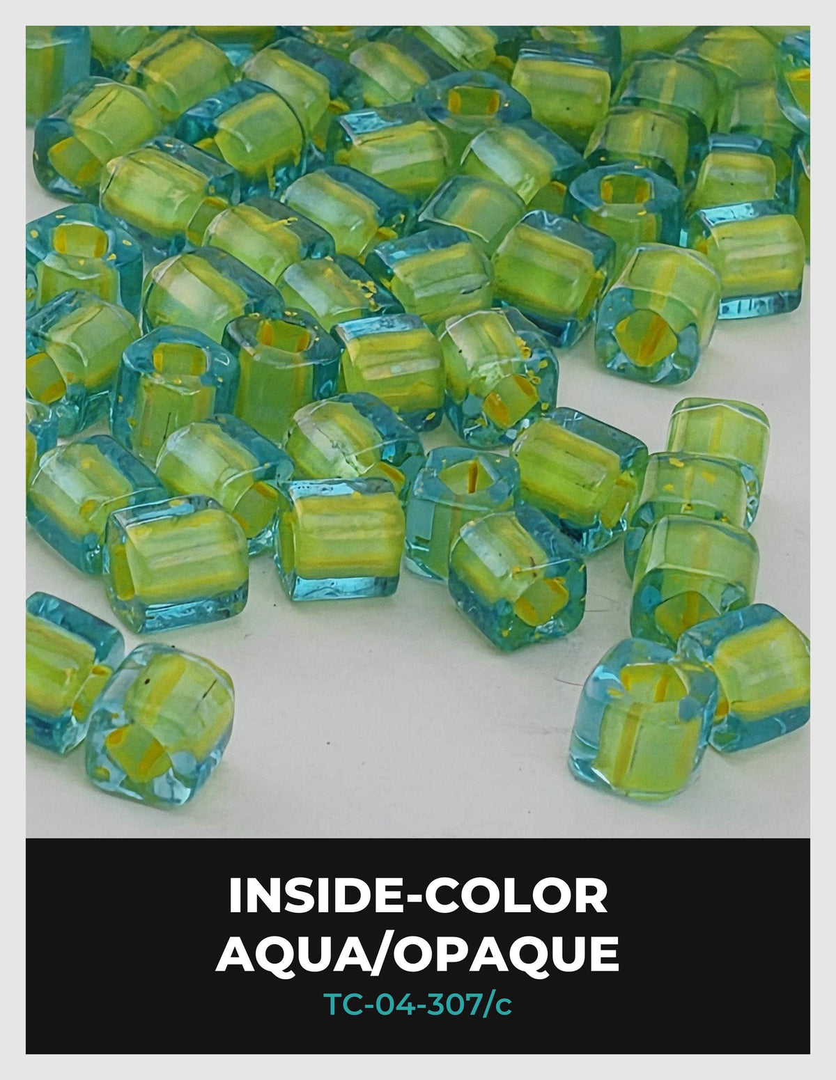 a collection of small, clear glass beads in various shades of green and yellow, scattered across a white background.