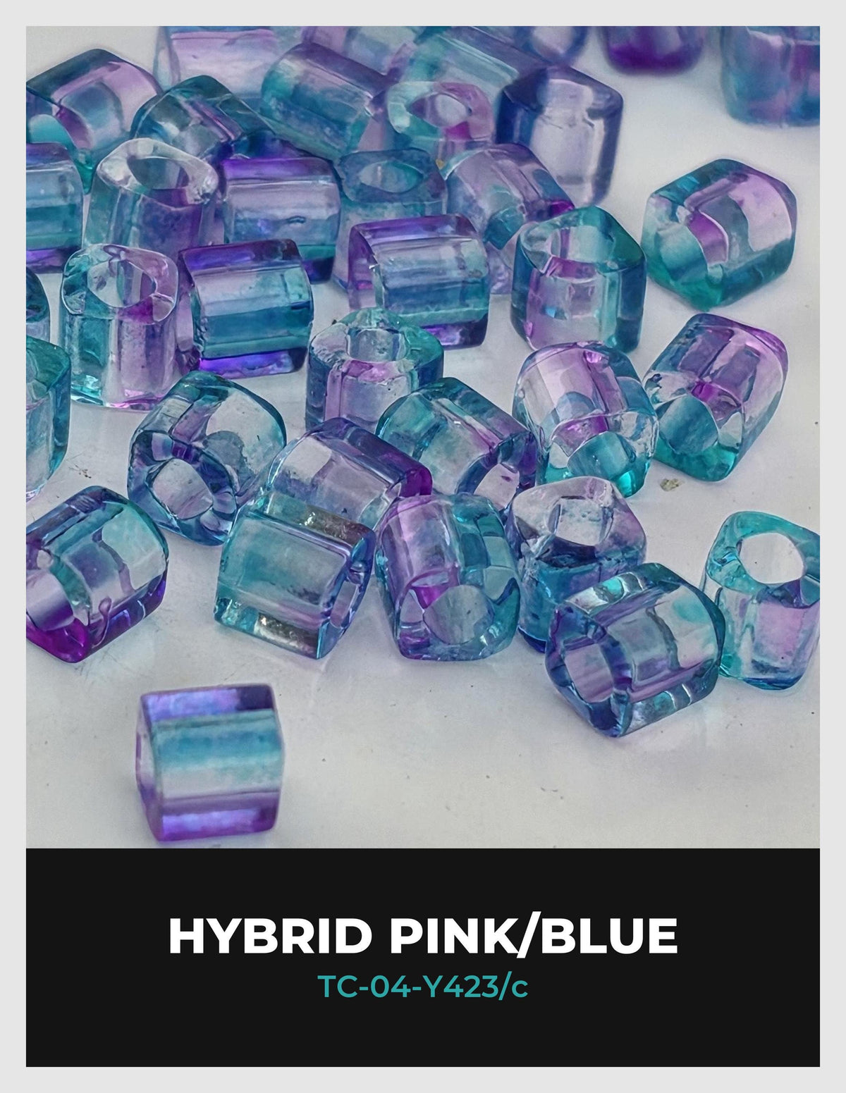 a collection of colorful glass beads in shades of pink and blue, scattered across a white background.