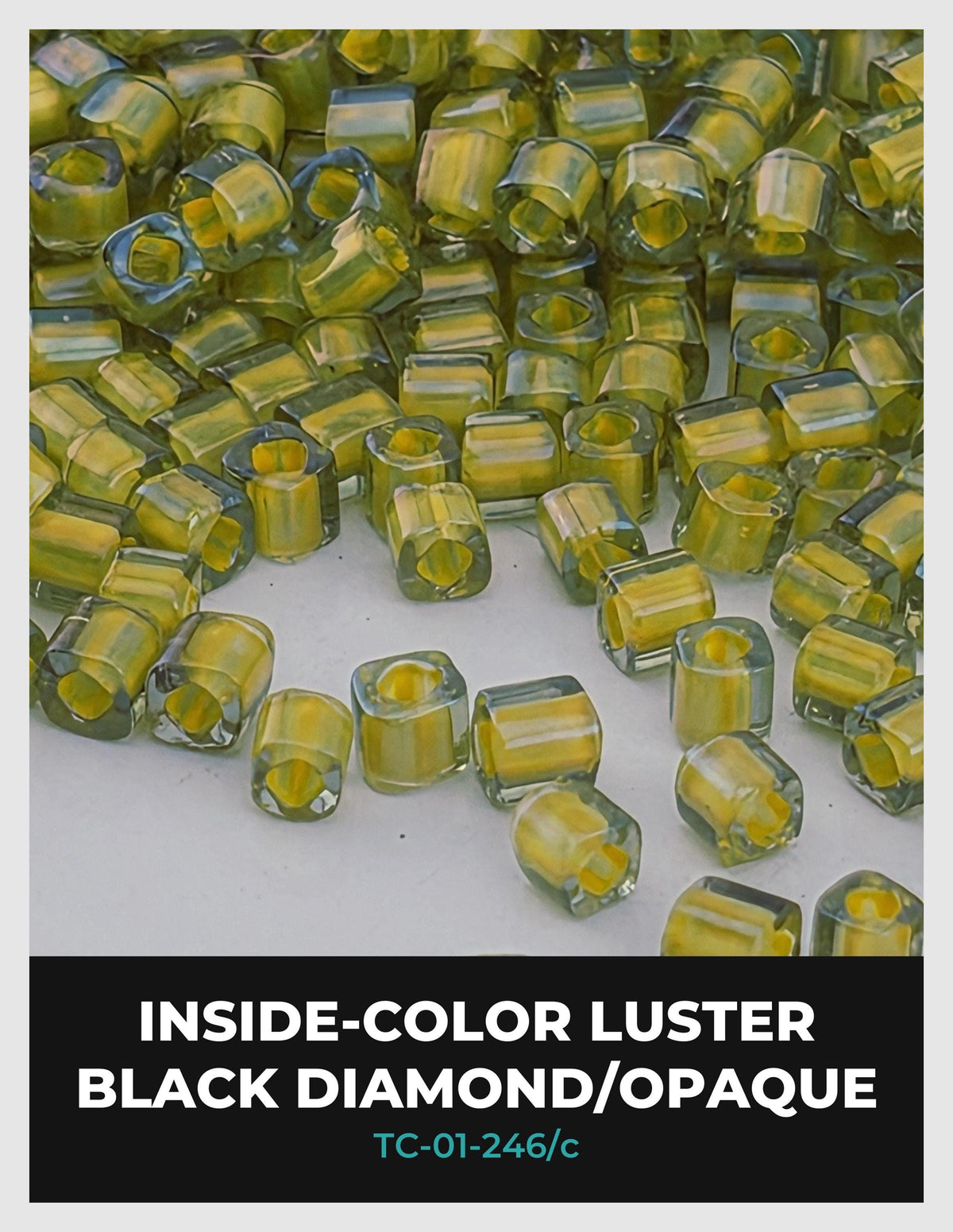 a collection of small, clear glass beads in various colors, including yellow, green, and black. The beads are scattered across a white surface, creating a visually striking contrast.