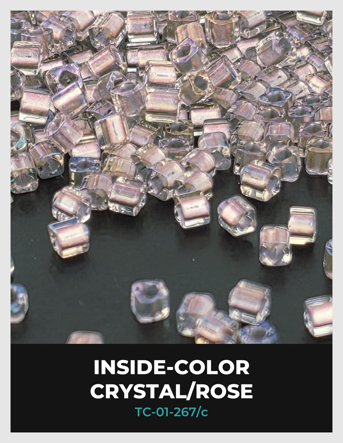The image is a close-up of numerous clear crystal beads or gemstones, scattered across a dark surface.