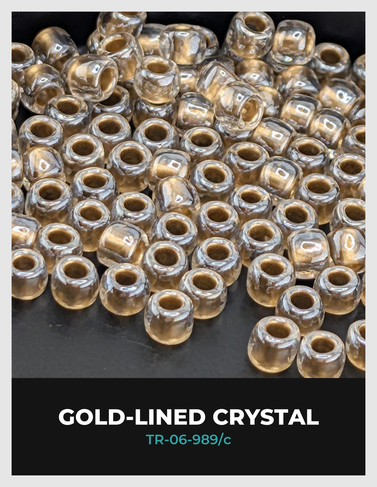 a collection of clear, gold-colored crystal beads arranged on a dark background.