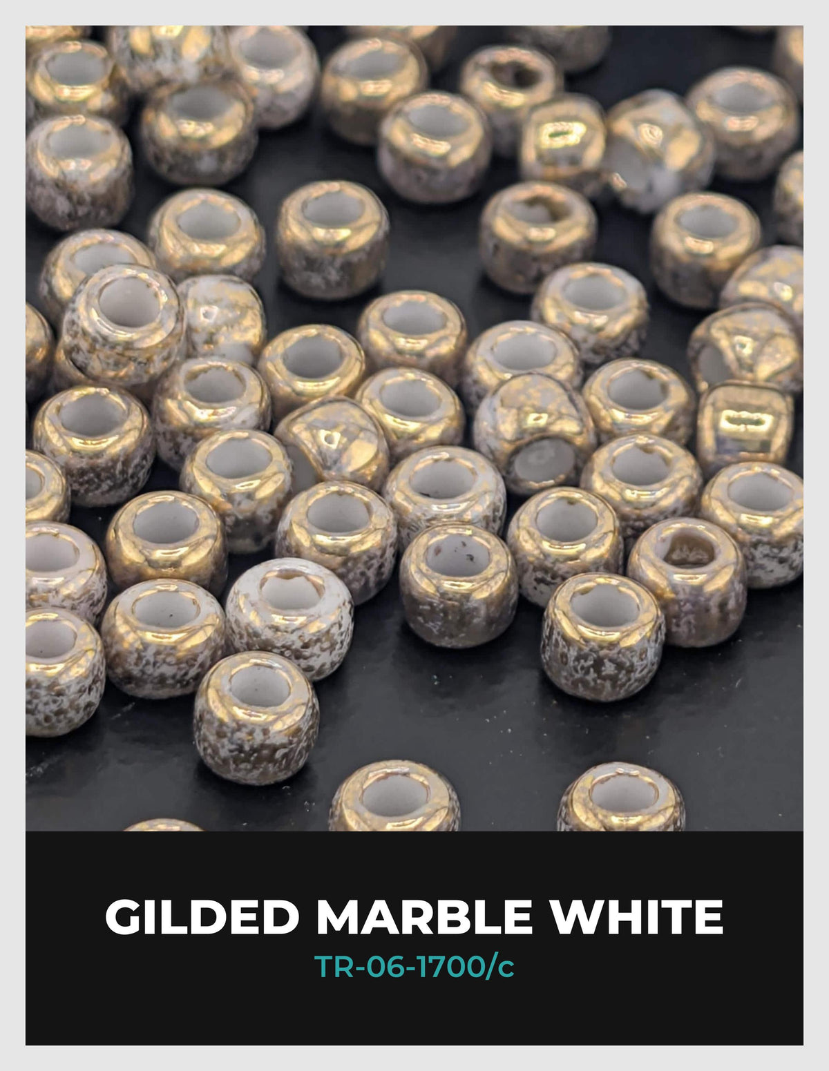 a close-up view of numerous small, round beads with a gilded finish, predominantly white in color. The beads are scattered across a dark background, creating a visually striking contrast.
