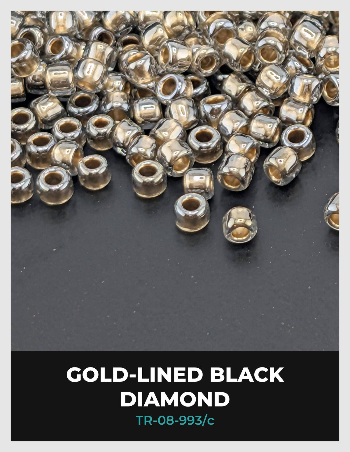 a collection of small, clear beads in various colors, including gold and black, scattered on a dark surface.
