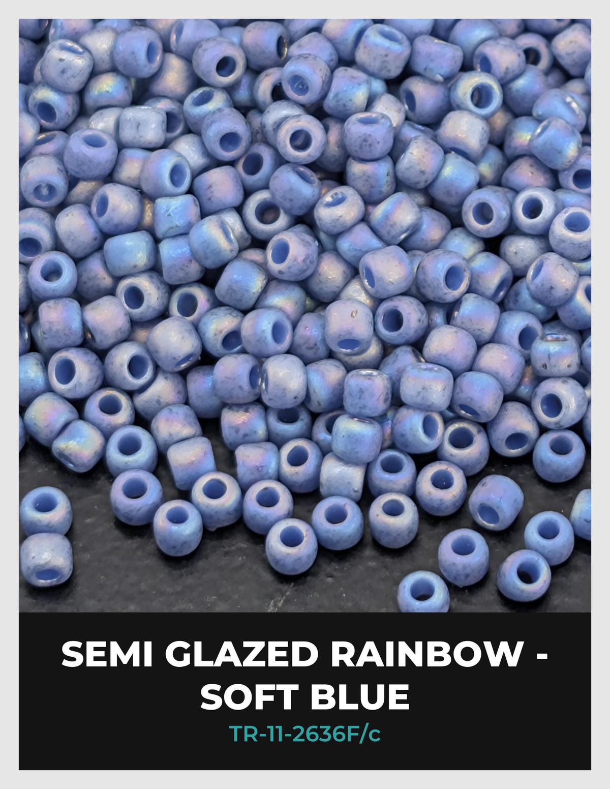 a large pile of semi-glazed rainbow-colored beads in various shades of blue, scattered on a dark surface.