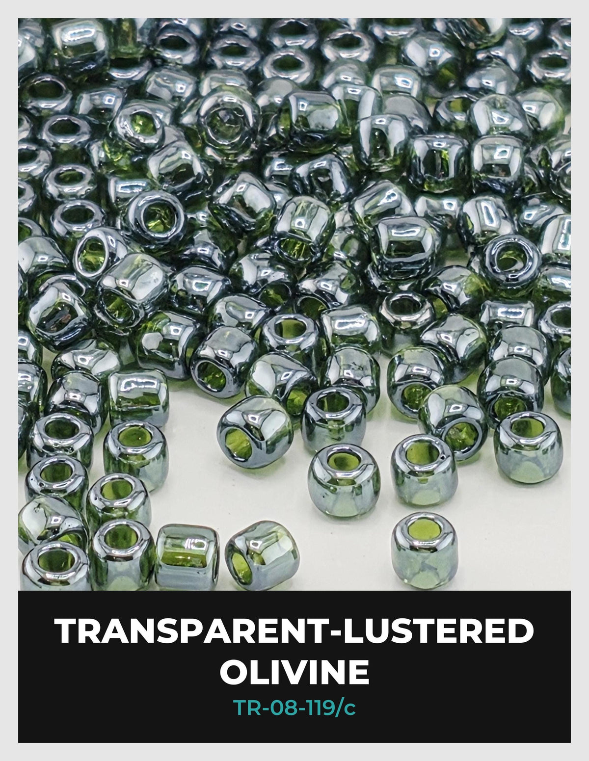 The image is a close-up of numerous transparent-lustered olive beads, with a focus on their shiny, metallic surfaces.