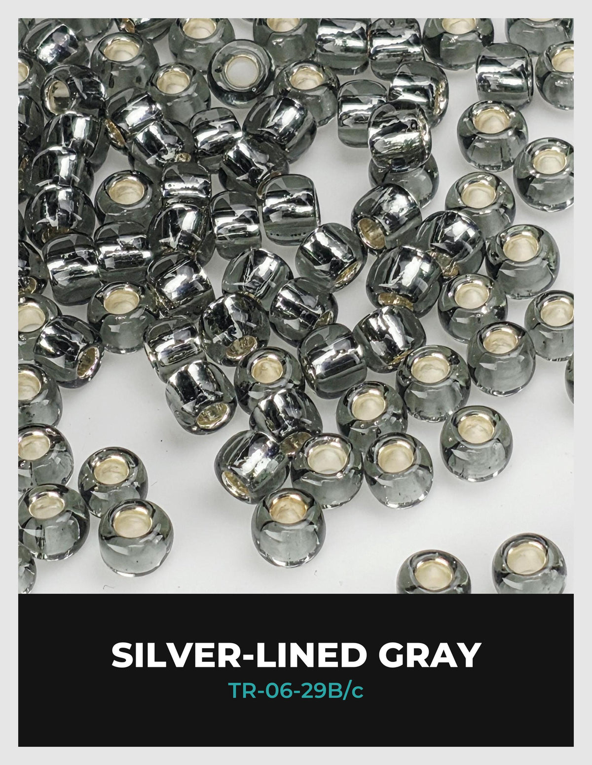 a collection of silver-lined gray beads scattered across a white background.