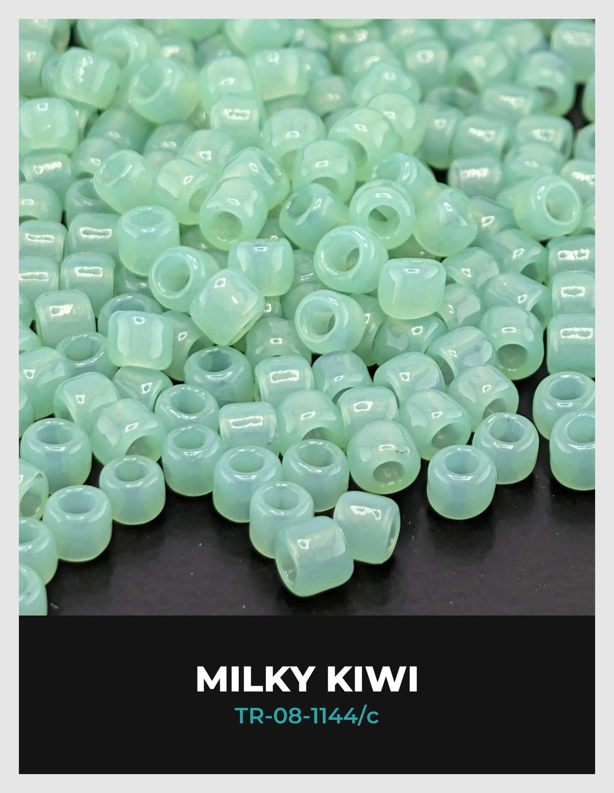 a collection of small, clear beads in various shades of green, scattered on a dark background.