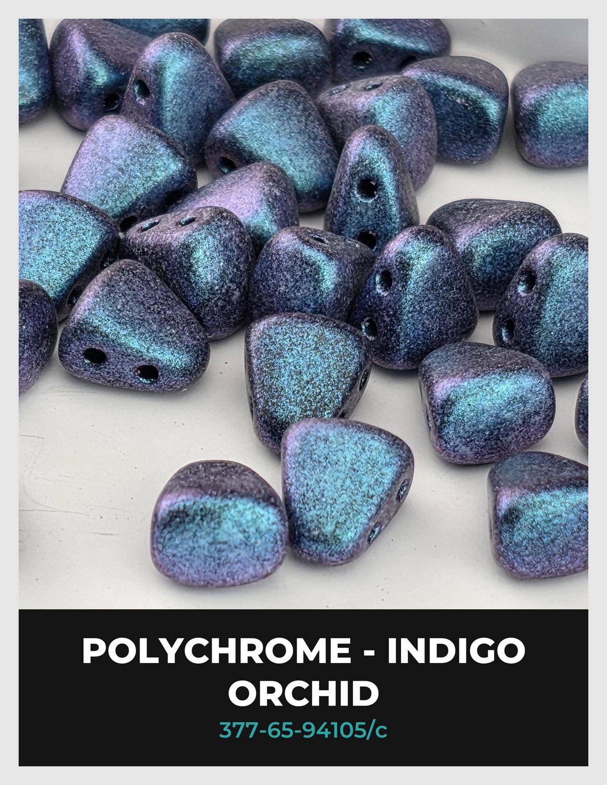 a collection of polychrome orchid beads in various shades of blue and purple, scattered on a white background.